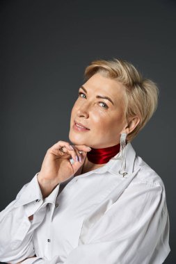 Şık bir kadın kendine güvenerek poz verir, şık kıyafetler giyer ve cesur aksesuarlar takar..