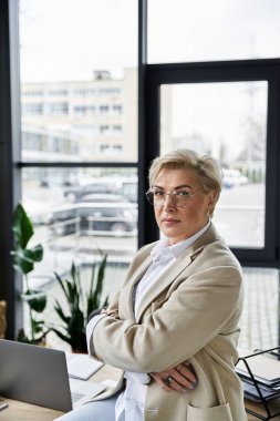 Şık bir kadın, çağdaş bir ofis ortamında poz verirken kendine güvenir..