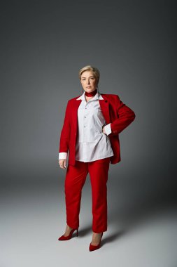 An adult woman exudes confidence in her tailored red suit, striking a bold pose. clipart