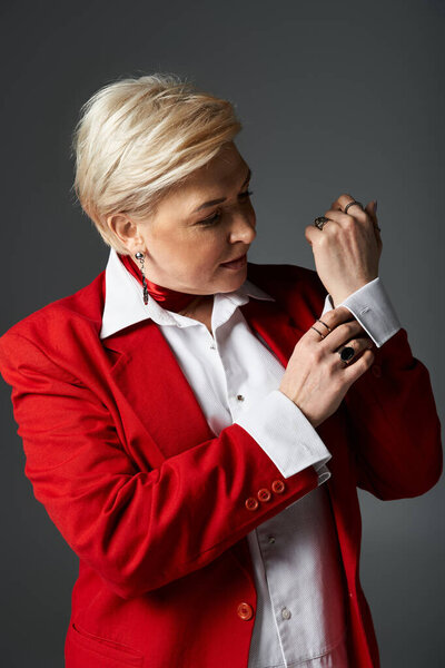 Модная женщина элегантно подстраивает рукав, излучая уравновешенность и изысканность..