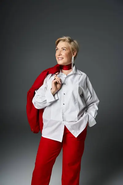 stock image An adult woman showcases her fashionable look with stylish confidence in a minimalist studio.