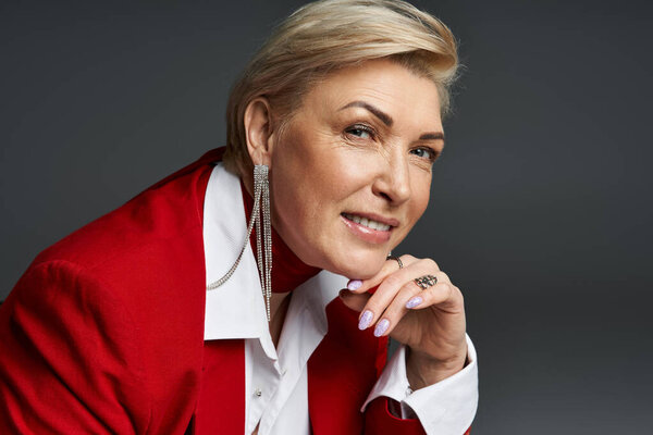 An adult woman radiates sophistication in elegant clothing, her expression thoughtful and poised.