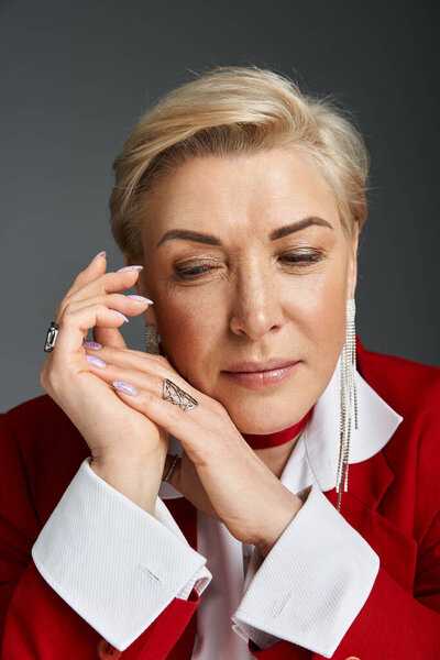 Взрослая стильная женщина демонстрирует элегантность и уравновешенность в ярком наряде.