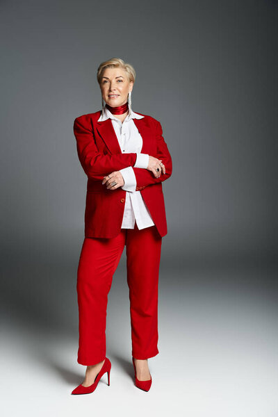 Элегантная женщина демонстрирует свой шикарный красный ансамбль, командует вниманием и изысканностью..