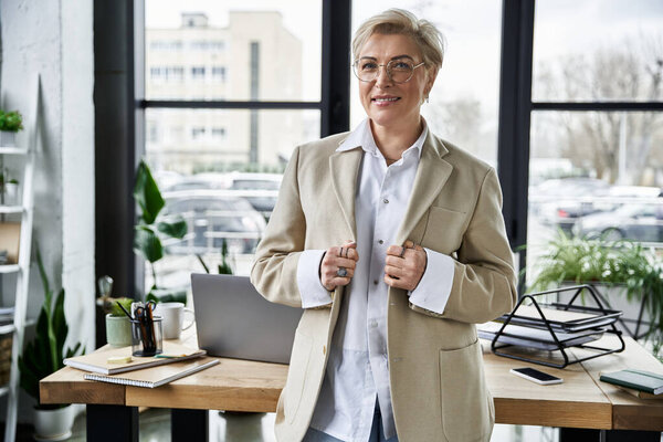An adult woman in chic attire embraces a professional atmosphere while posing indoors.