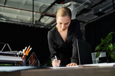Kendini işine adamış genç bir kadın modern bir ofis ortamında çalışırken görevlerine odaklanıyor..