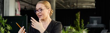 A young woman in an office setting passionately discusses ideas while holding a pencil. clipart