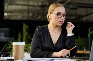 Genç, güzel, iri yarı bir kadın ofiste beyin fırtınası yaparken dizüstü bilgisayarıyla meşgul oluyor..