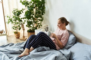 Cozy moments unfold as a young plus size woman sips tea in her stylish bedroom, feeling peaceful. clipart