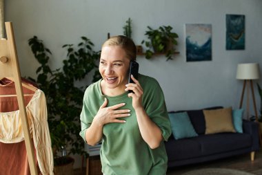 Neşeli genç bir kadın evinde canlı bir telefon görüşmesi yapıyor..