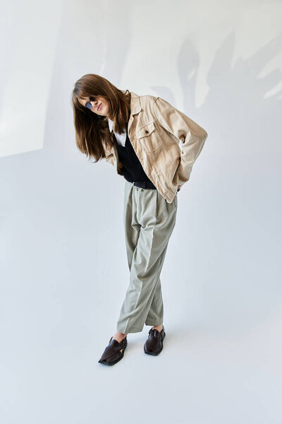 A young fashionable guy poses with confidence in modern attire, exuding a vibrant energy.