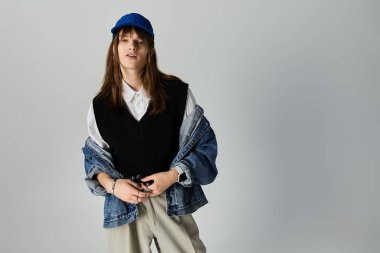 Moda kıyafetleri giymiş genç bir adam kendine güven yayıyor. Aynı zamanda eşsiz bir görünüşü var..