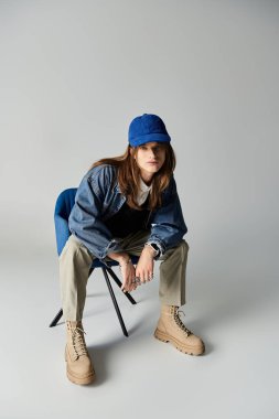 Moda kıyafetleri içinde genç bir adam şık bir stüdyoda poz verirken kendine güveniyor..