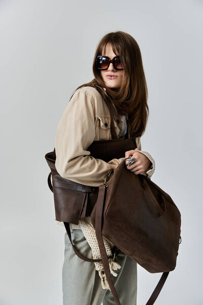 Этот молодой, модный человек держит различные сумки, экссудативный стиль и уверенность в городской одежде.