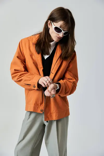 stock image A trendy young individual adjusts his accessories while wearing an eye catching ensemble.