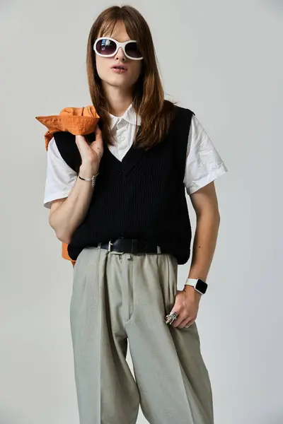 stock image A young man stands confidently, displaying his stylish outfit and bold fashion choices.