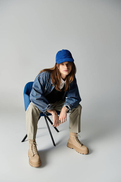 Одетый в модные наряды, молодой человек излучает уверенность, позируя в шикарной студии.