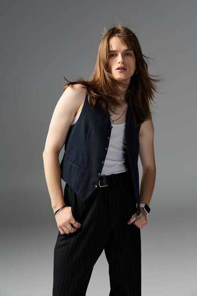 Молодой парень выставляет напоказ свое чувство стиля со стильным жилетом и расслабленным поведением.