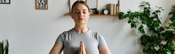 Молодая женщина в активном ношении практикует свои тренировки дома, олицетворяя силу и преданность.