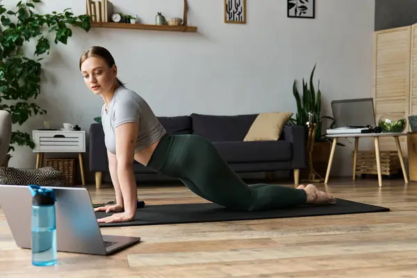 stock image A young sportive woman engages in a home workout in comfortable active wear, focused and energized.