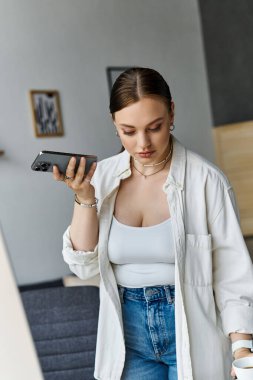 Genç bir kadın telefonuyla konuşuyor. Ev işyerinde rahatlık ve verimliliği birleştiriyor..