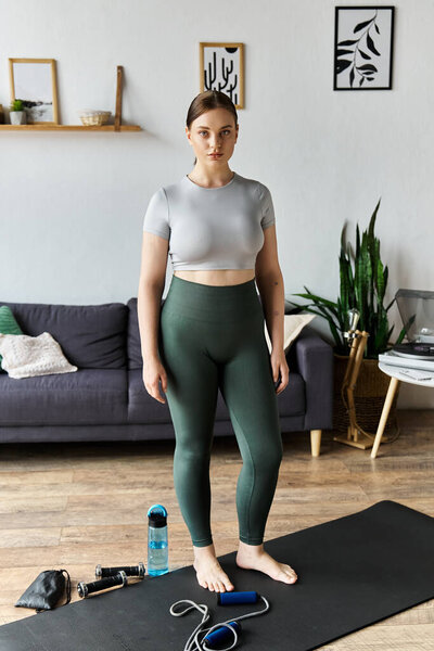 A dedicated young woman is exercising at home, showcasing her sporty attire while focusing on fitness.