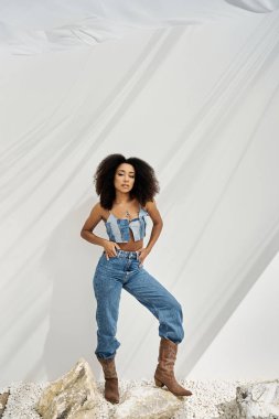 Kendine güvenen genç bir Afrikalı Amerikalı kadın moda anlayışını şık bir grupta sergiliyor..