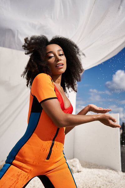 Эта сияющая молодая женщина демонстрирует свой стильный наряд, весело наслаждаясь солнечным светом.