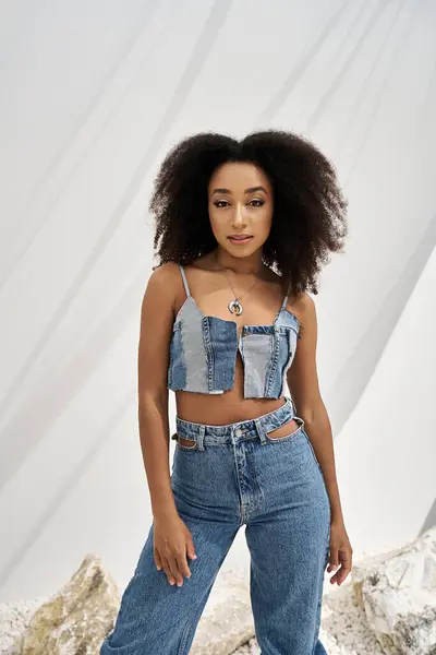 stock image A young african american woman flaunts her stylish denim outfit and bright smile.