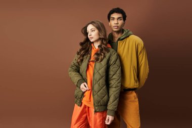 Modaya uygun genç bir çift şık sonbahar kıyafetleri içinde poz veriyor, sıcaklık ve canlılık saçıyor..