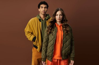 Şık bir çift sonbahar kıyafetlerini sergiliyor. Renkli kıyafetler içinde sıcaklık ve moda yayıyorlar..