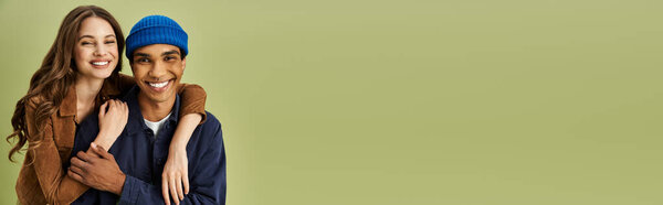 A stylish couple embraces warmly, showcasing their colorful fall outfits with joy and flair.