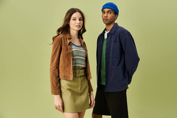 Стильная пара, одетая в осенние вдохновляющие наряды на ярком фоне привлекает внимание.