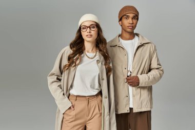 Şık genç bir çift canlı sonbahar kıyafetlerini göstererek mevsimi kucaklıyor..