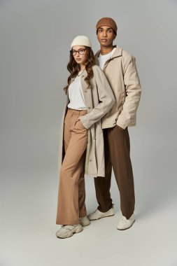 Moda bir çift şık katmanları ve aksesuarlarıyla canlı bir sonbahar modası sergiliyor..