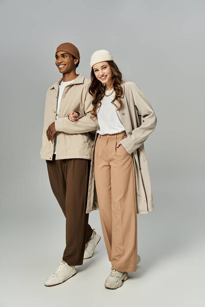 A fashionable couple walks together, dressed in vibrant autumn attire, radiating joy and warmth.