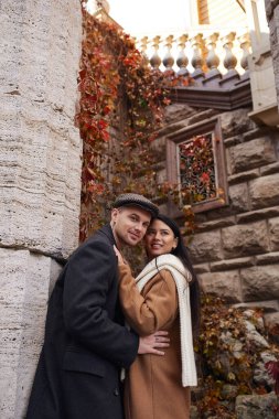 Sevgi dolu bir çift, doğayla dolu büyüleyici sonbahar renklerinde bir ortamda sıcak bir şekilde kucaklaşır..