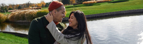 Любящая пара нежно обнимается на фоне ярких осенних красок у озера.