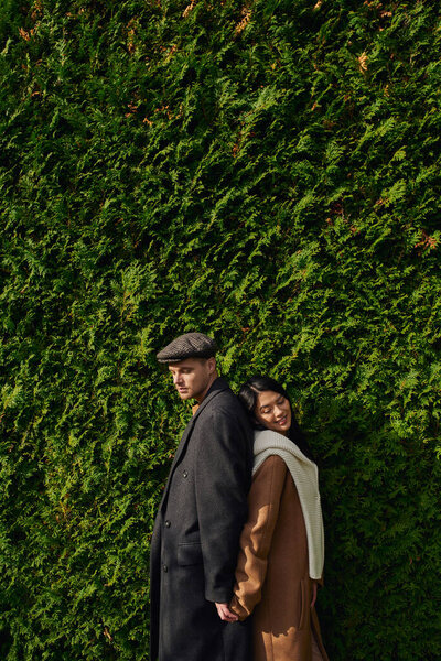 A couple embraces warmly while surrounded by vibrant autumn foliage, radiating love and joy.