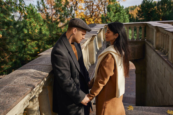 A couple shares a warm connection on a beautiful autumn day in nature.