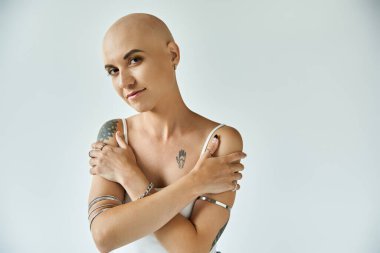 Genç bir kadın benzersizliğini kucaklıyor, özgüvenini ve güzelliğini alopecia ile gösteriyor..