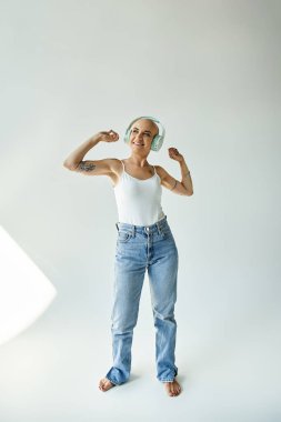 Parlak bir tebessümü olan genç bir kadın gücünü ve güvenini gösterirken gülümsüyor..