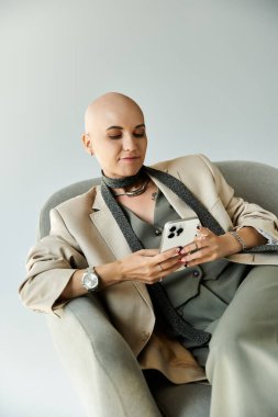 Sakin bir an, akıllı telefonunda özümsenmiş, zarif giyinmiş kel bir kadını yakalar..