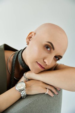 Genç kel bir kadın zarif bir şekilde poz verir, yumuşak ışıkta gücünü gösterir..