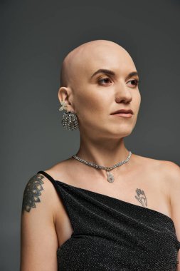 Alopecia 'lı genç bir kadın kendine güvenir. Zarif mücevherler ve çarpıcı kıyafetlerle süslenir..