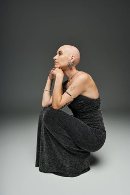 Alopecia hastası genç bir kadın zarif, derin düşüncelere dalmış, eşsiz güzelliğini sergiliyor..