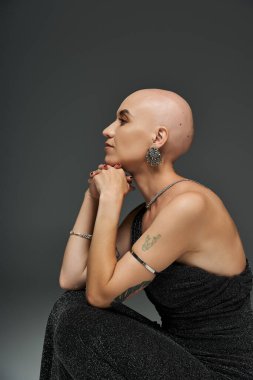 Genç kel bir kadın zarif bir şekilde poz verir, eşsiz güzelliğini ve gücünü gösterir..