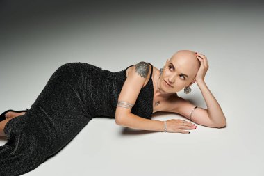 Alopecia hastası genç bir kadın zarif bir şekilde rahatlar, özgüvenini ve güzelliğini gösterir..