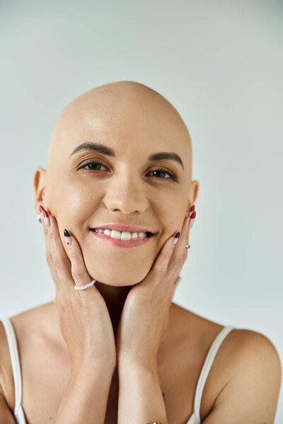 Молодая женщина уверенно представляет свою уникальную красоту, обнимая свою алопецию с изяществом.