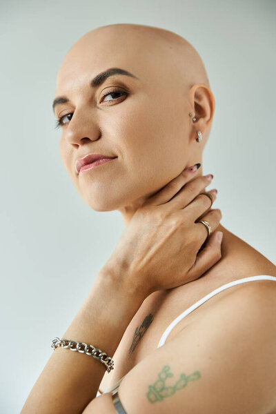 Молодая женщина с облысением изящно позирует, подчеркивая ее поразительные черты лица и самолюбие.